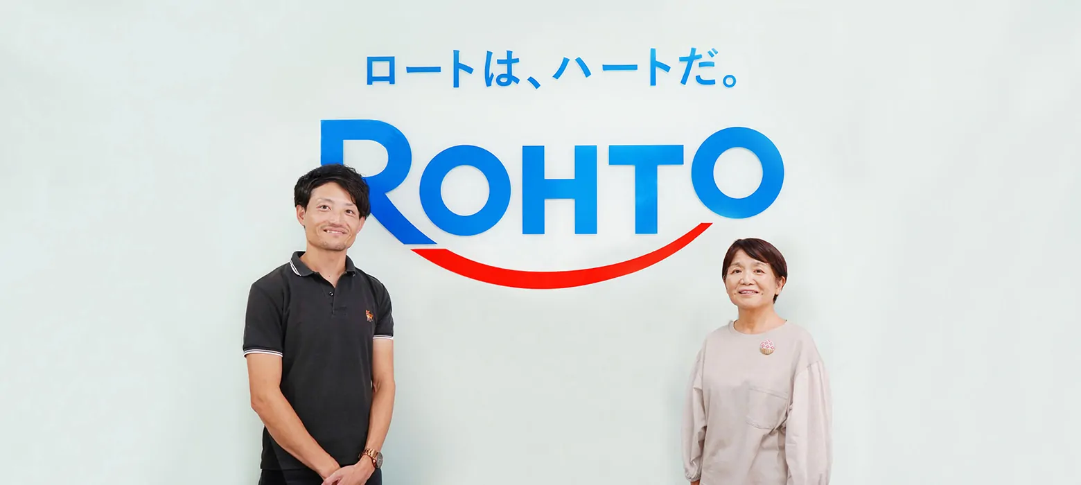 キャッチコピー“ロートは、ハートだ。”とROHTOのロゴを背景に、男性と女性が左右に並んで微笑んでいる